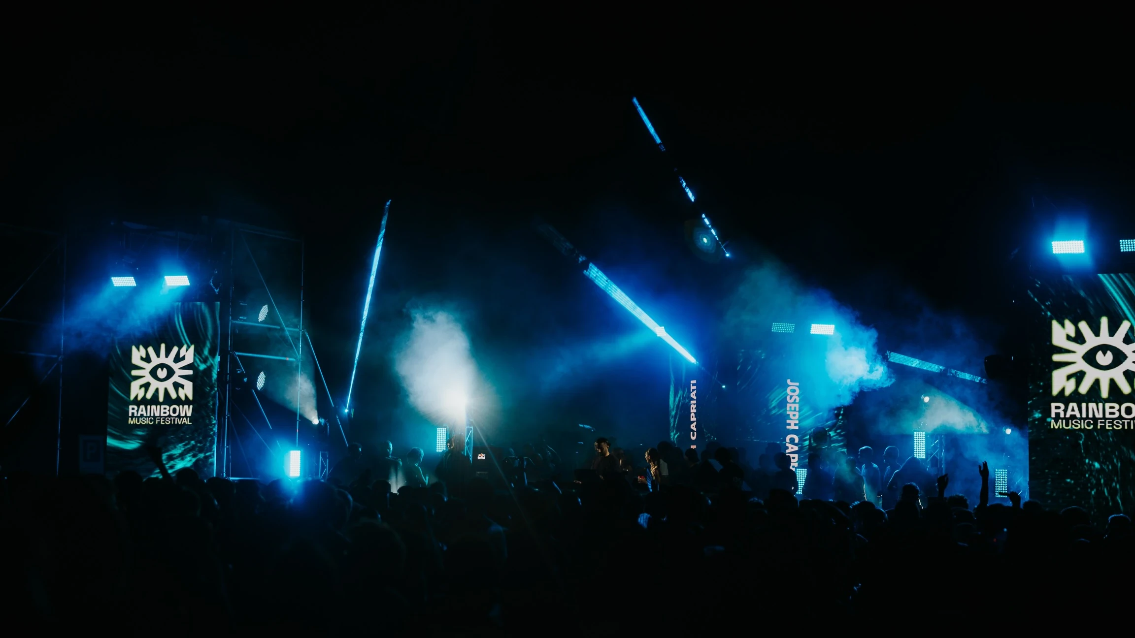 Il palco e il pubblico immersi nelle luci blu del festival
